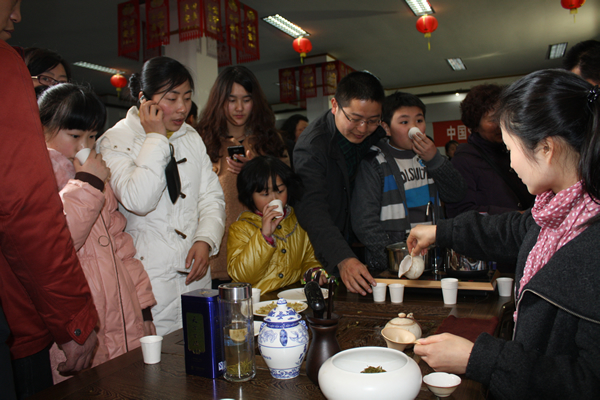 眾多遊人駐足天方展位前品霧裡青、嘗茶食品、觀(guān)茶藝表演